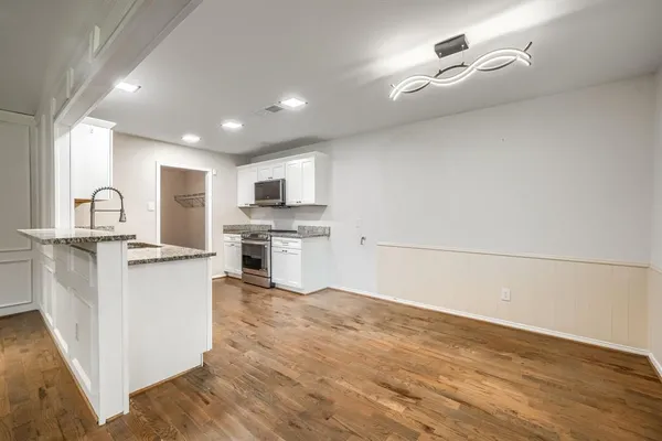 a kitchen with white cabinets and appliances