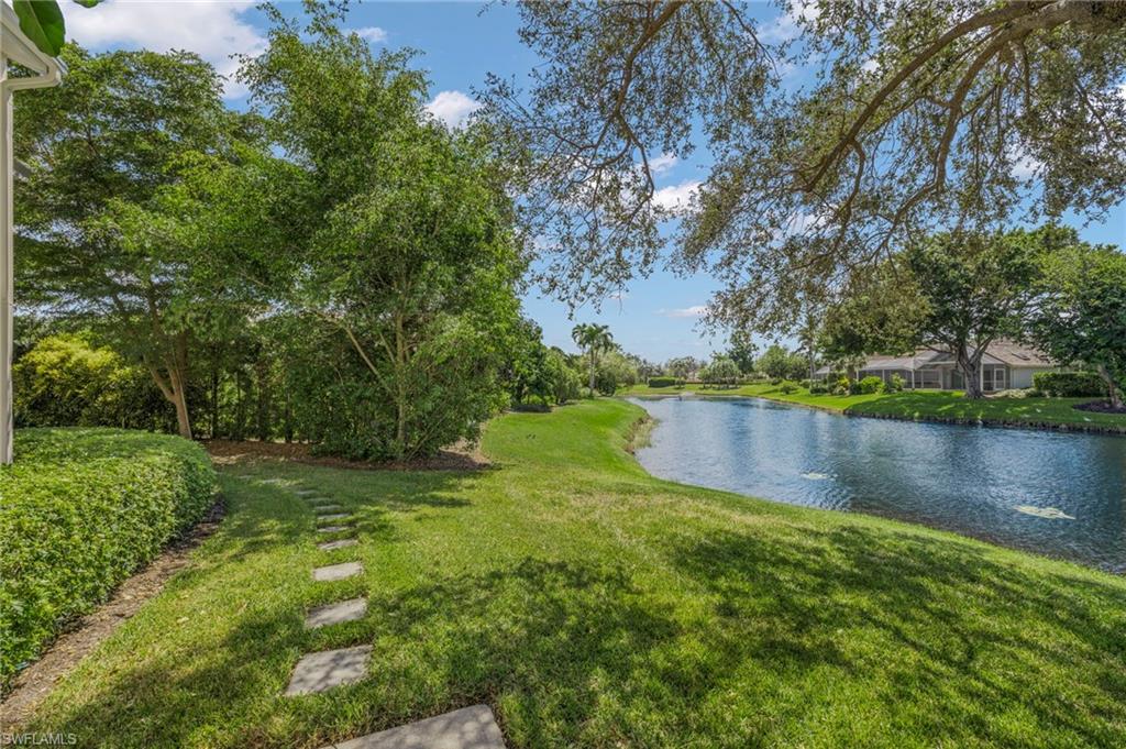 793 Willowbrook Drive, Unit 104 Naples, FL 34108 - Photo 18 of 38 a view of a lake with a yard and large trees