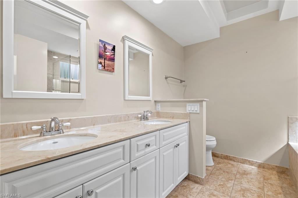 793 Willowbrook Drive, Unit 104 Naples, FL 34108 - Photo 25 of 38 a bathroom with a granite countertop sink and a mirror