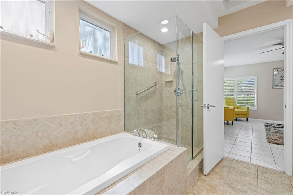 793 Willowbrook Drive, Unit 104 Naples, FL 34108 - Photo 26 of 38 a bathroom with a tub a sink and a shower