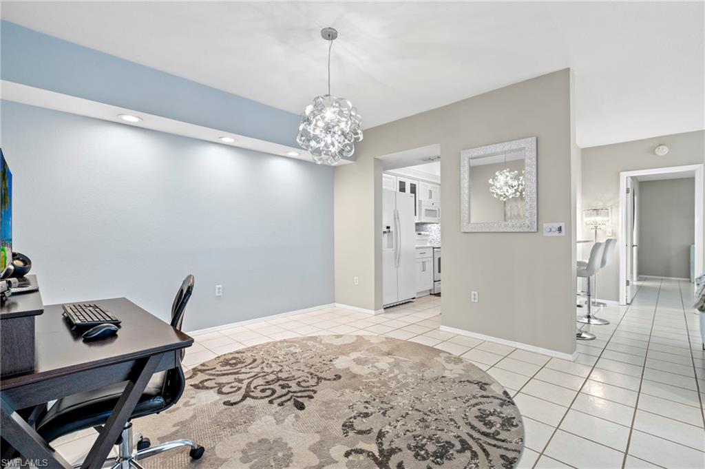 793 Willowbrook Drive, Unit 104 Naples, FL 34108 - Photo 29 of 38 a bedroom with a bed and a chandelier