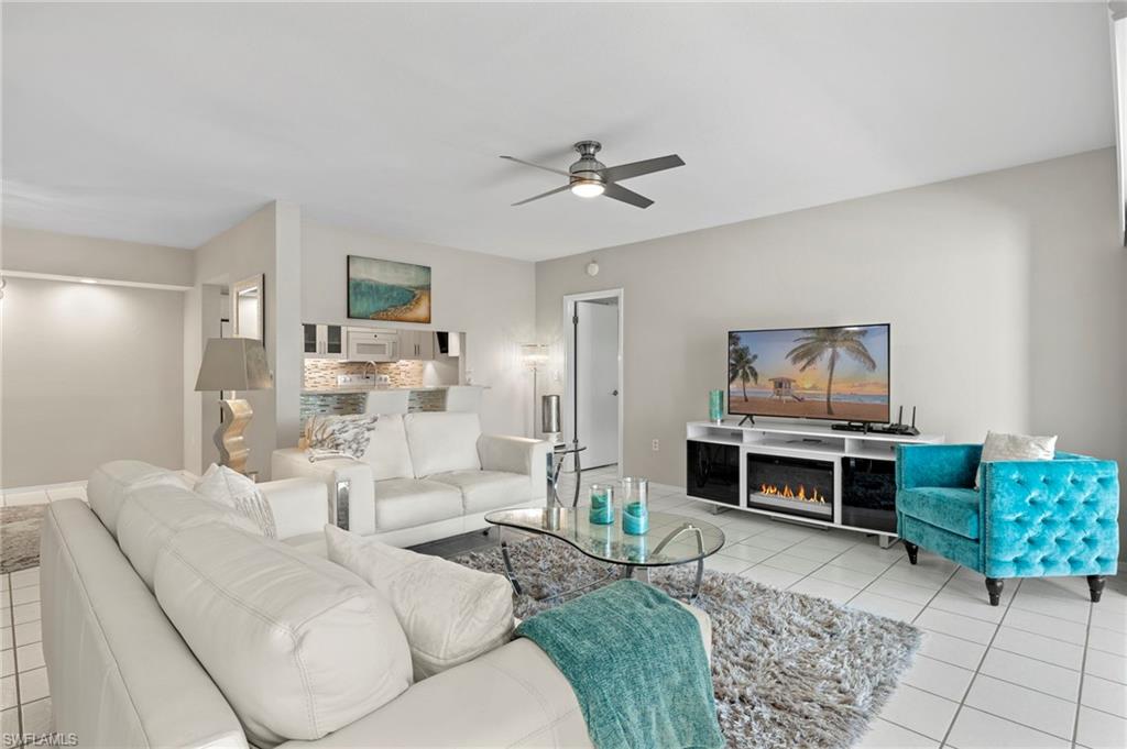 793 Willowbrook Drive, Unit 104 Naples, FL 34108 - Photo 32 of 38 a living room with furniture and a fireplace