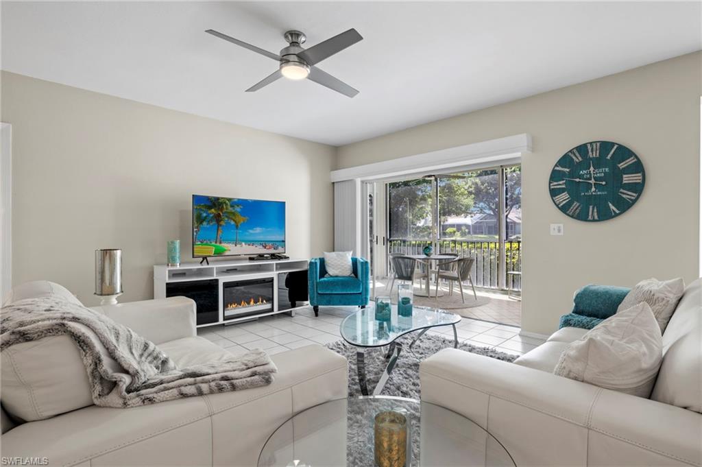 793 Willowbrook Drive, Unit 104 Naples, FL 34108 - Photo 33 of 38 a living room with furniture a flat screen tv and a large window