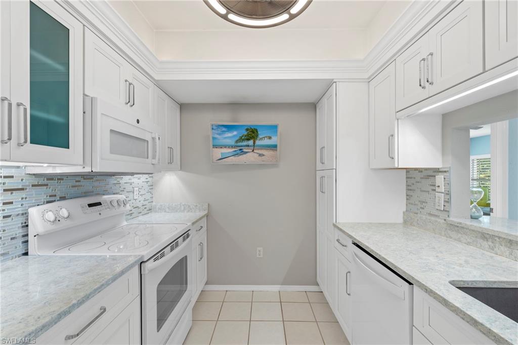 793 Willowbrook Drive, Unit 104 Naples, FL 34108 - Photo 35 of 38 a spacious bathroom with a granite countertop sink and a mirror