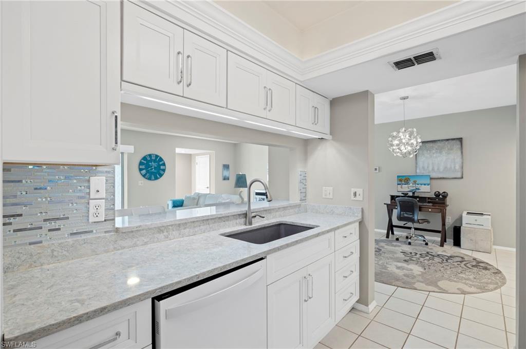 793 Willowbrook Drive, Unit 104 Naples, FL 34108 - Photo 36 of 38 a kitchen with granite countertop a sink and cabinets