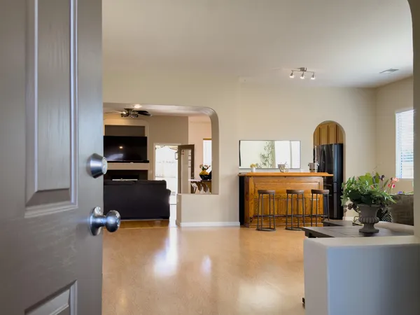a kitchen with stainless steel appliances granite countertop a stove top oven a sink dishwasher a dining table and chairs with wooden floor