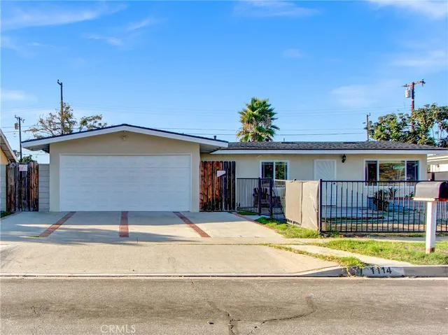 a view of a house with a patio and a yard