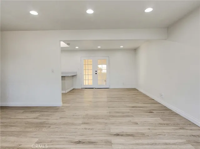 a view of empty room with wooden floor and window