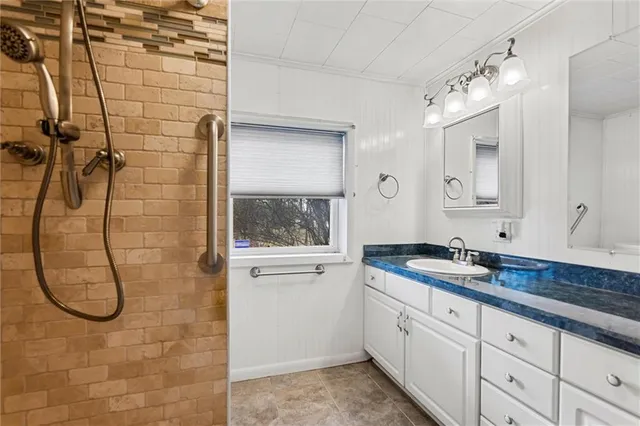 a bathroom with a granite countertop sink a toilet and shower