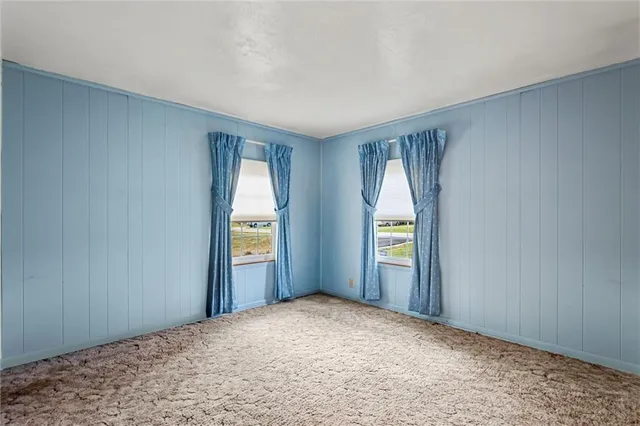 an empty room with windows and cabinet