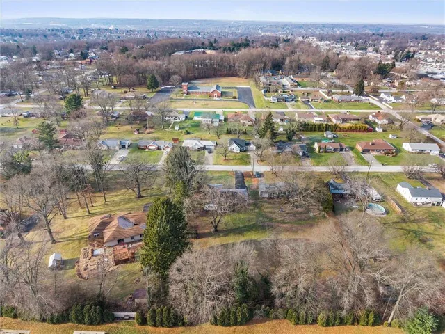 a front view of a house with a yard and large trees
