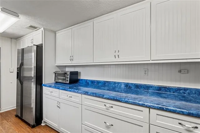 a kitchen with granite countertop white cabinets and stainless steel appliances