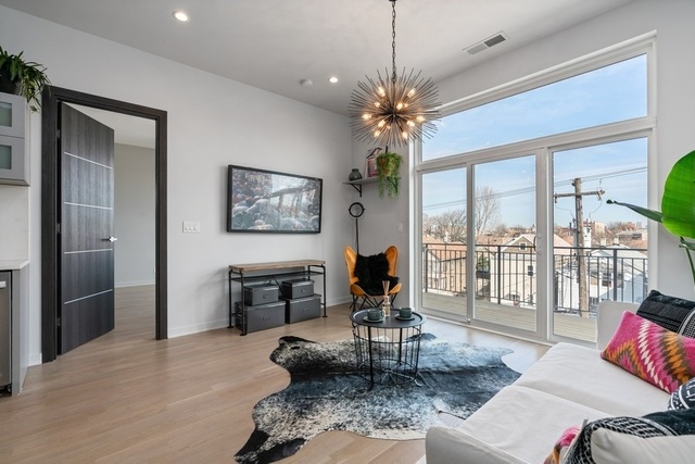 1708 West Cermak Road, Unit 2E Chicago, IL 60608 - Photo 15 of 49 a living room with furniture a flat screen tv and a floor to ceiling window