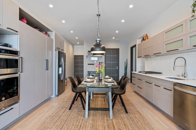 1708 West Cermak Road, Unit 2E Chicago, IL 60608 - Photo 17 of 49 a kitchen with stainless steel appliances granite countertop a kitchen island hardwood floor sink stove dining table and chairs