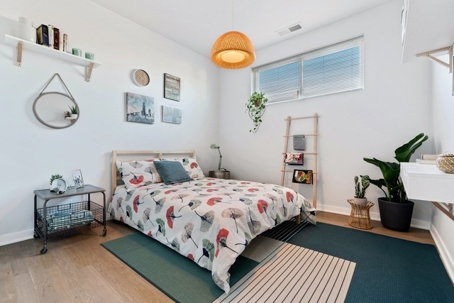 1708 West Cermak Road, Unit 2E Chicago, IL 60608 - Photo 37 of 49 a bedroom with a bed and a chandelier