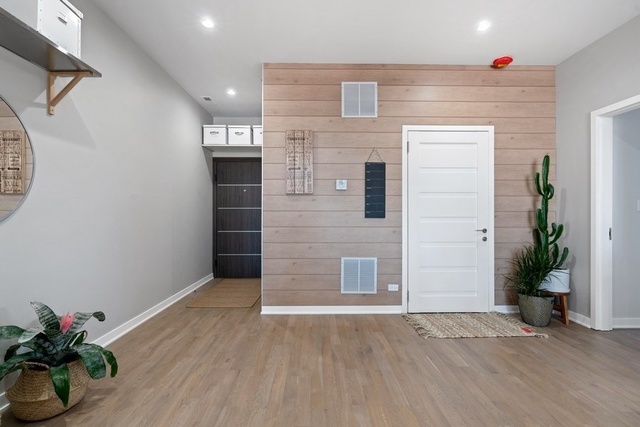 1708 West Cermak Road, Unit 2E Chicago, IL 60608 - Photo 41 of 49 a view of a hallway with wooden floor and a potted plant