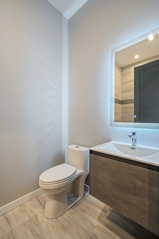 1708 West Cermak Road, Unit 2E Chicago, IL 60608 - Photo 47 of 49 a bathroom with a toilet a sink and mirror