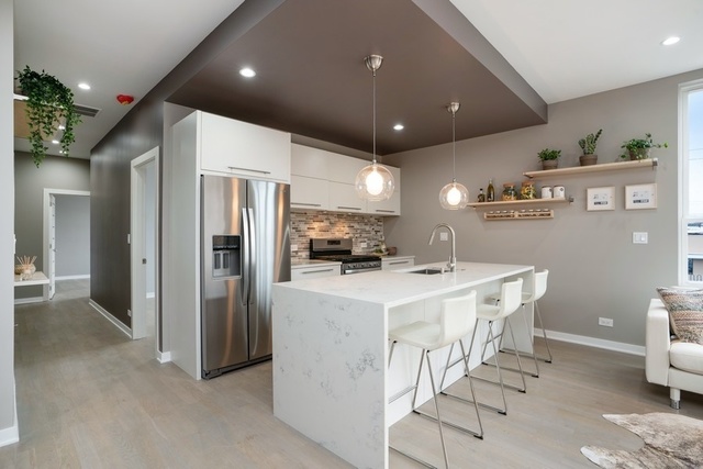 1708 West Cermak Road, Unit 2E Chicago, IL 60608 - Photo 7 of 49 a kitchen with stainless steel appliances kitchen island a refrigerator sink and cabinets