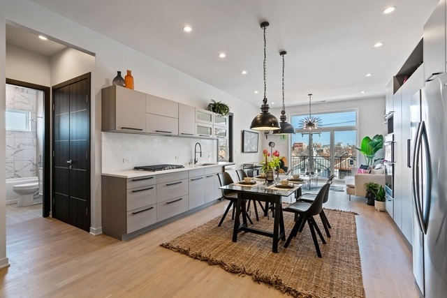 1708 West Cermak Road, Unit 2E Chicago, IL 60608 - Photo 10 of 49 a kitchen with stainless steel appliances kitchen island granite countertop a table chairs and a refrigerator