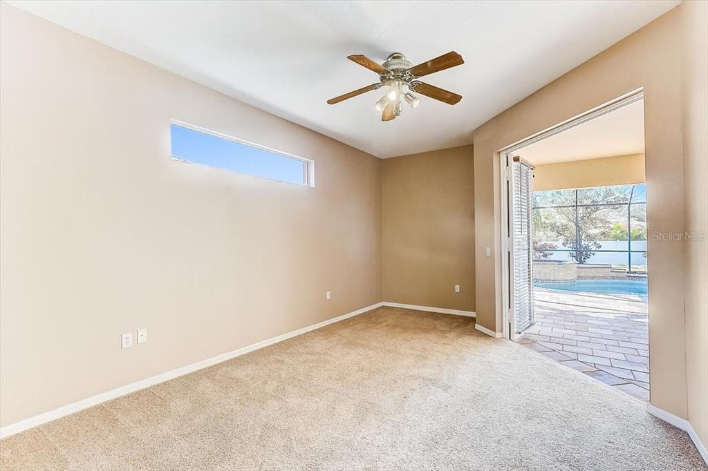 6214 Warbler Lane Lakewood Ranch, FL 34202 - Photo 17 of 40 an empty room with chandelier fan and windows