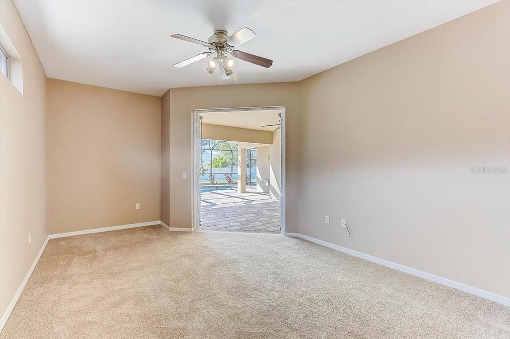 6214 Warbler Lane Lakewood Ranch, FL 34202 - Photo 18 of 40 an empty room with a chandelier fan and windows
