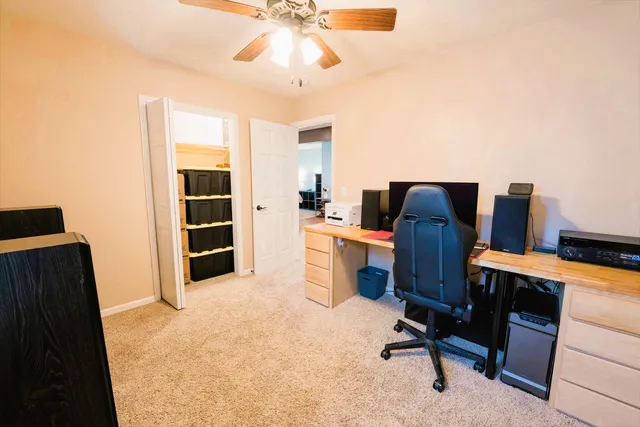 a view of a workspace with furniture and a window