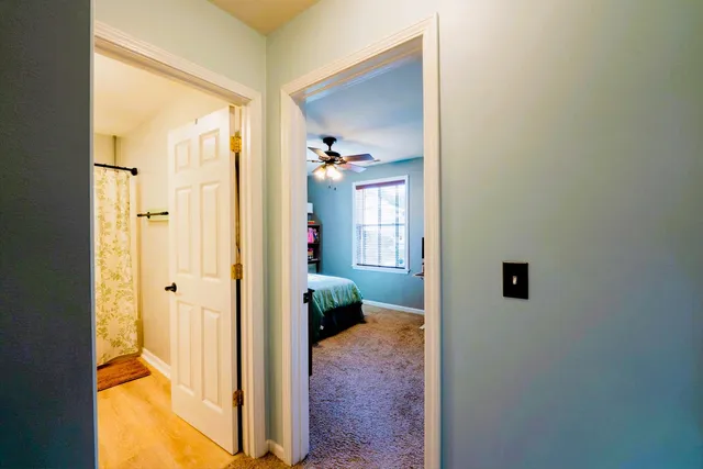 a view of a hallway with wooden floor and a living room