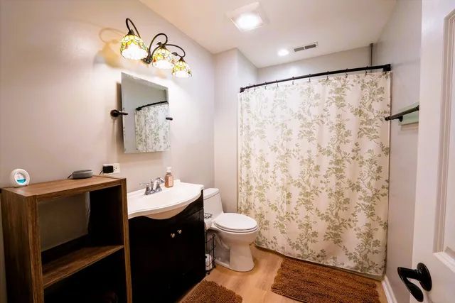 a bathroom with a sink vanity mirror and toilet