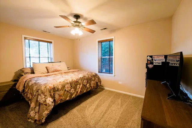a bed sitting in a bedroom next to a window and a chandelier