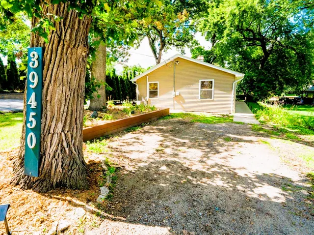 a view of backyard of house with wooden fence