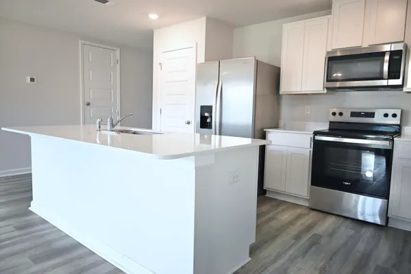 a view of kitchen with wooden floor and electronic appliances