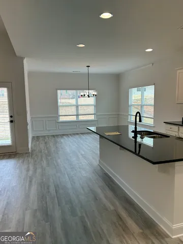 a large kitchen with kitchen island a sink and wooden floor