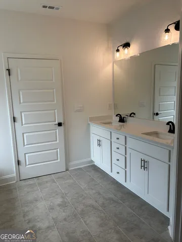 a spacious bathroom with a sink and a mirror