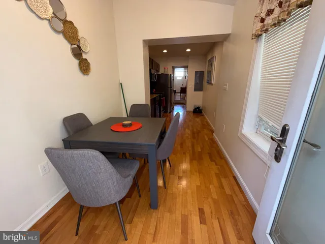 a living room with dining room and wooden floor