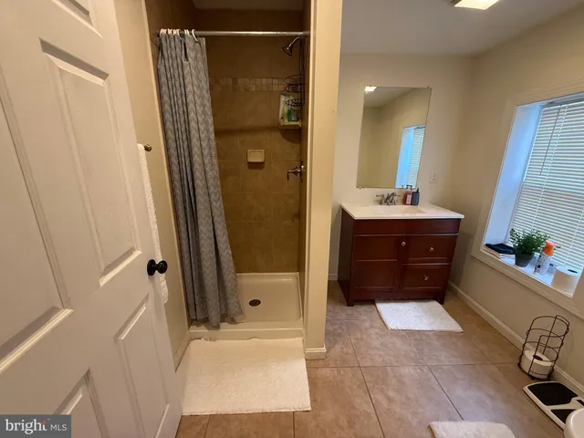 a bathroom with a tub a sink and a mirror