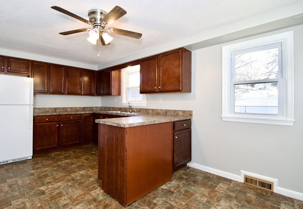 71 Mayflower Road Springfield, MA 01118 - Photo 11 of 42 a kitchen with stainless steel appliances granite countertop a stove a sink dishwasher and a refrigerator with wooden cabinets