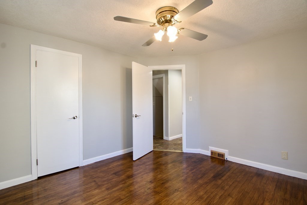 71 Mayflower Road Springfield, MA 01118 - Photo 22 of 42 an empty room with wooden floor chandelier fan and closet area