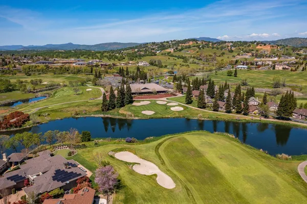 an aerial view of a house with a garden and lake view