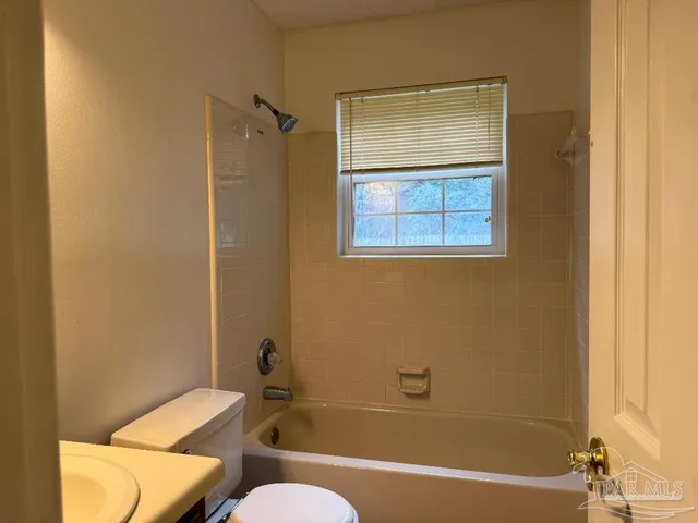 a bathroom with a sink mirror bathtub and toilet