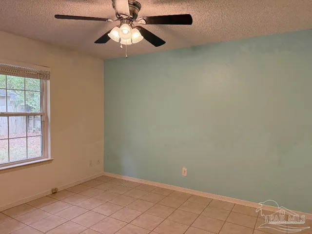 an empty room with windows and fan