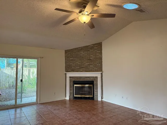 a view of a livingroom with a fireplace and a chandelier fan