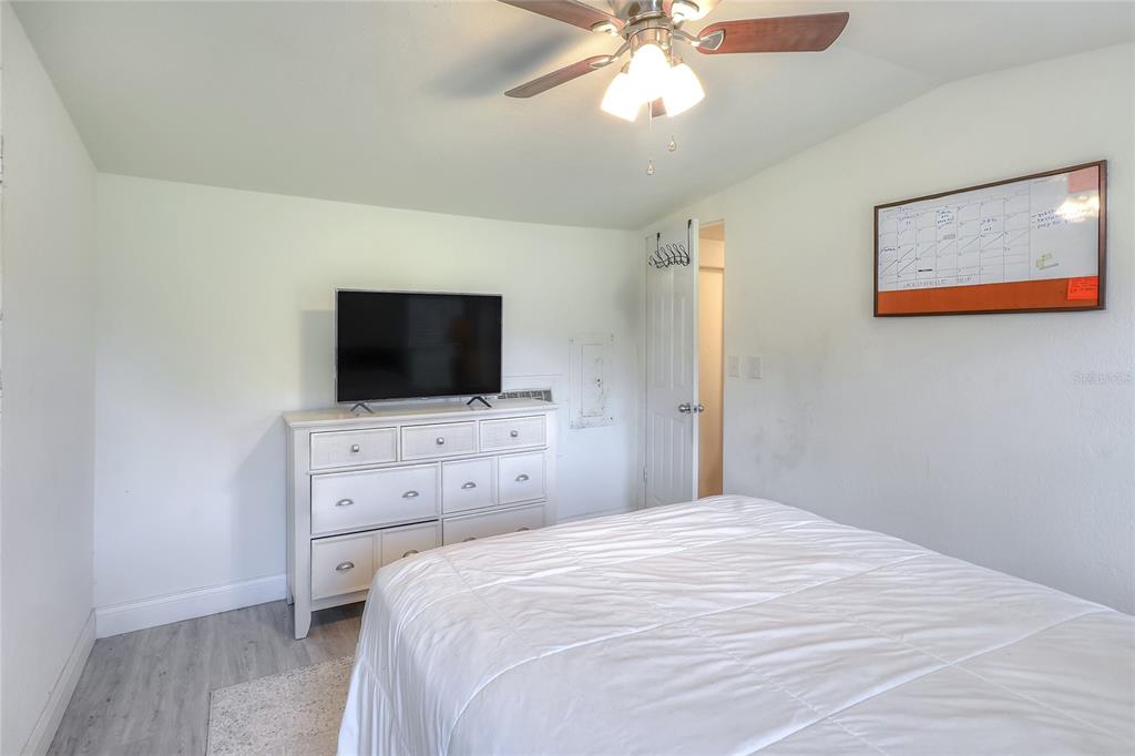 12552 Farmettes Road Lakeland, FL 33809 - Photo 14 of 43 a bedroom with a flat screen tv and a chandelier