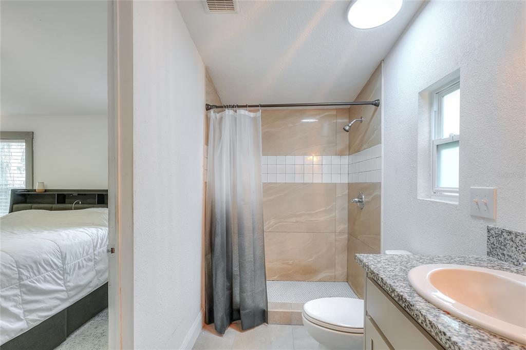 12552 Farmettes Road Lakeland, FL 33809 - Photo 19 of 43 a bathroom with a granite countertop sink toilet and shower