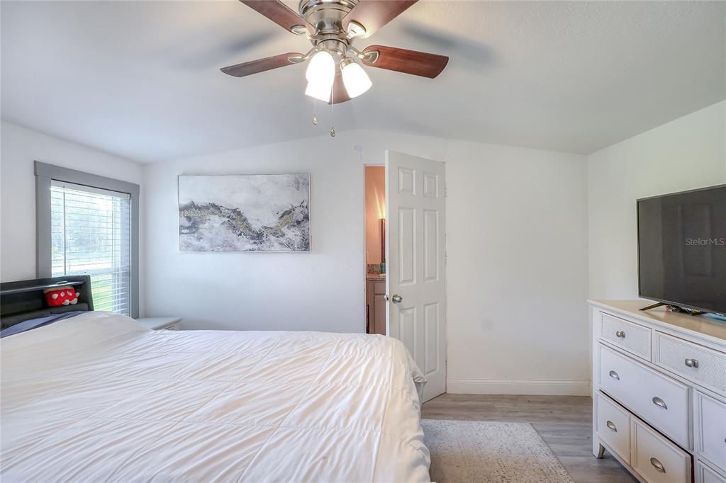 12552 Farmettes Road Lakeland, FL 33809 - Photo 20 of 43 a bedroom with a bed and a flat tv screen on the dresser