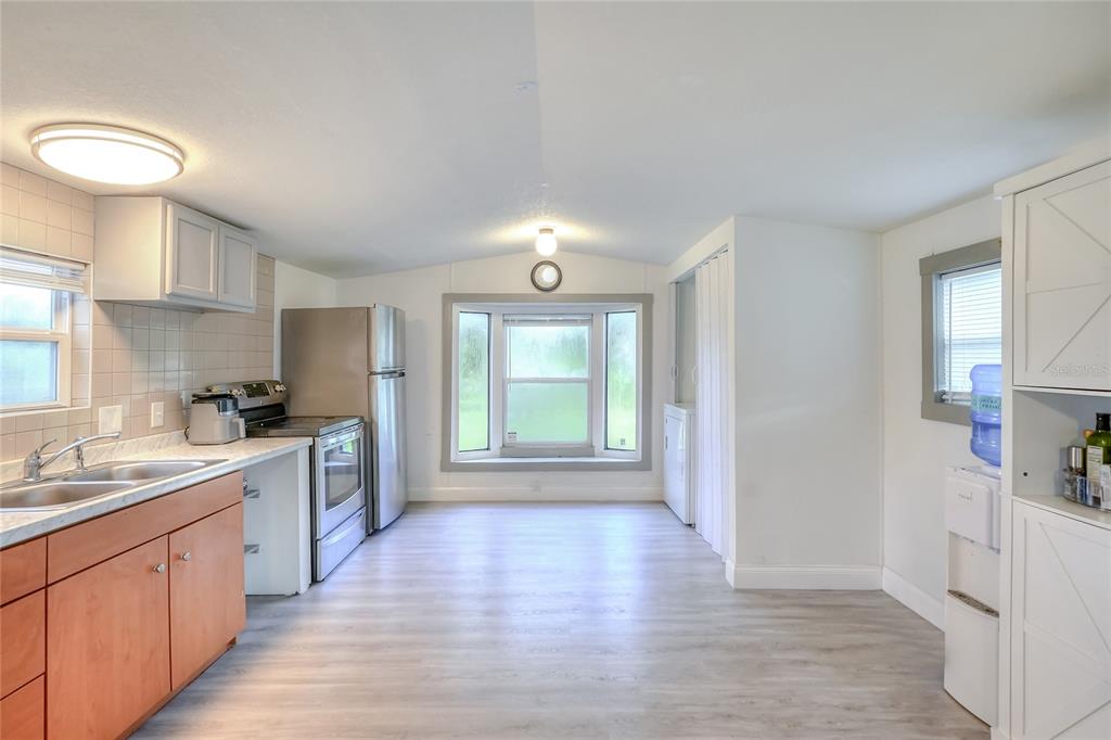 12552 Farmettes Road Lakeland, FL 33809 - Photo 6 of 43 a large kitchen with stainless steel appliances granite countertop a lot of counter space and wooden floors
