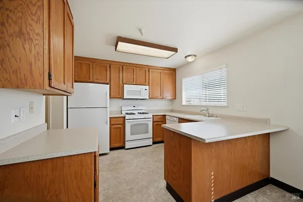 a kitchen with stainless steel appliances granite countertop a sink a stove and a refrigerator