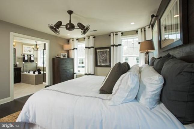 7682 Elmcrest Road Hanover, MD 21076 - Photo 13 of 21 a spacious bedroom with a bed and a chandelier