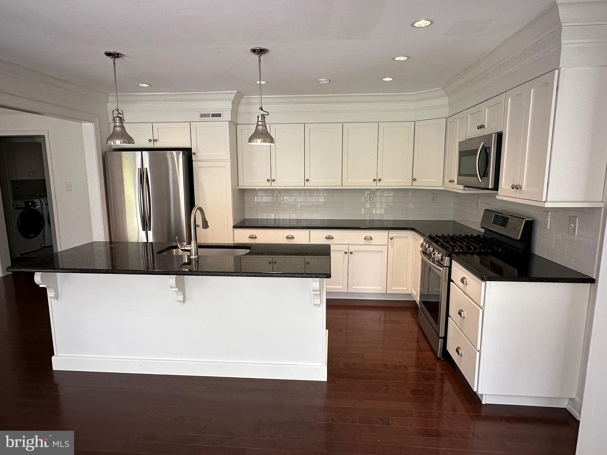 418 Waynesbrooke Road Berwyn, PA 19312 - Photo 9 of 30 a large kitchen with stainless steel appliances a sink a stove and white cabinets