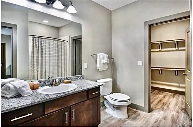 a bathroom with a granite countertop toilet sink and shower
