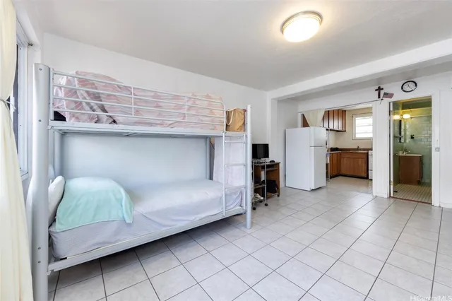 a living room with furniture and a refrigerator